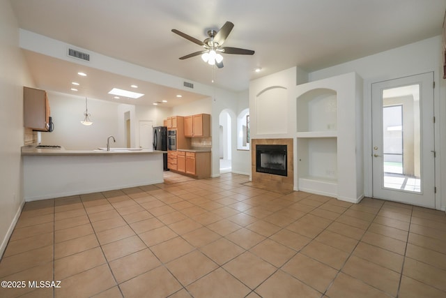 14085 E Copper Mesa Ct, Vail, AZ 85641 - kitchen featuring open floor plan, light tile patterned floors, a fireplace, a peninsula, and ceiling fan