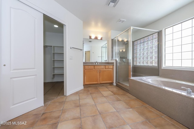 14085 E Copper Mesa Ct, Vail, AZ 85641 - bathroom with vanity, a shower stall, a bath, tile patterned floors, and a spacious closet