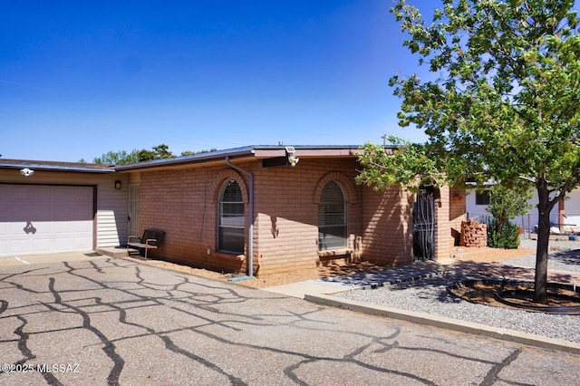 326 N Sage St, Pearce, AZ 85625 - view of front of house featuring an attached garage, asphalt driveway, and brick siding