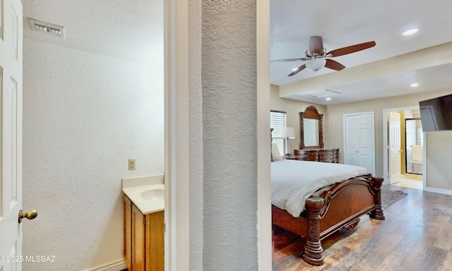8942 N Ferber Ct, Tucson, AZ 85742 - bedroom with a textured wall, wood-type flooring, connected bathroom, and recessed lighting