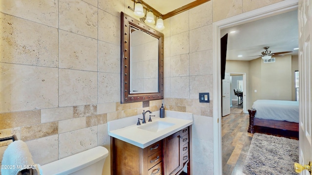 8942 N Ferber Ct, Tucson, AZ 85742 - bathroom featuring tile walls, vanity, a ceiling fan, wood finished floors, and recessed lighting
