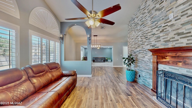 8942 N Ferber Ct, Tucson, AZ 85742 - living room featuring a fireplace, wood finished floors, ceiling fan, and lofted ceiling
