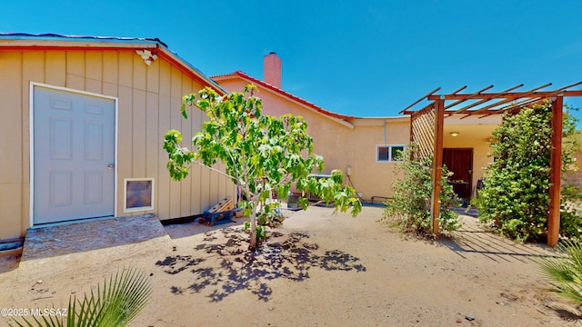 8942 N Ferber Ct, Tucson, AZ 85742 - exterior space featuring a chimney, a pergola, a patio area, and a tile roof
