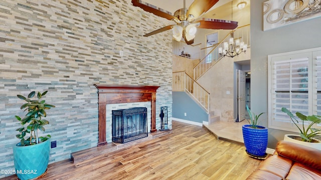 8942 N Ferber Ct, Tucson, AZ 85742 - living area featuring a ceiling fan, stairs, wood finished floors, a fireplace, and a towering ceiling