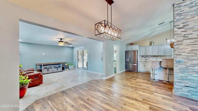 8942 N Ferber Ct, Tucson, AZ 85742 - unfurnished living room with light wood-type flooring, a ceiling fan, and vaulted ceiling