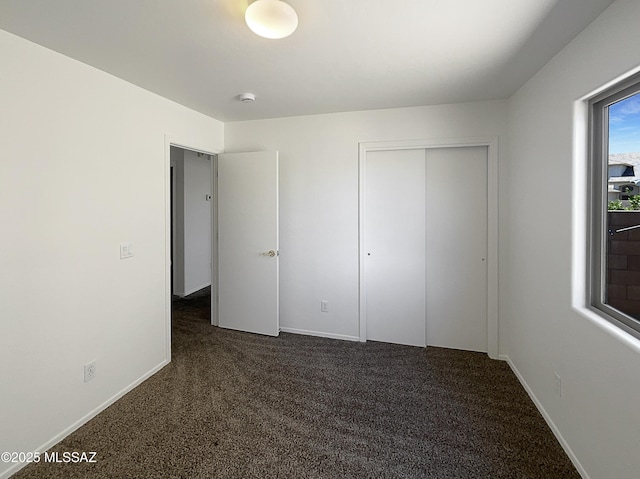 8758 E Mountain Spring Dr, Tucson, AZ 85747 - unfurnished bedroom with dark colored carpet and a closet