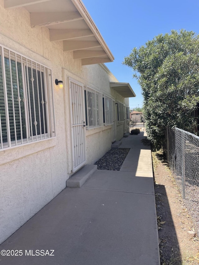 1809 E Miles St, Tucson, AZ 85719 - view of side of property featuring stucco siding and a patio area