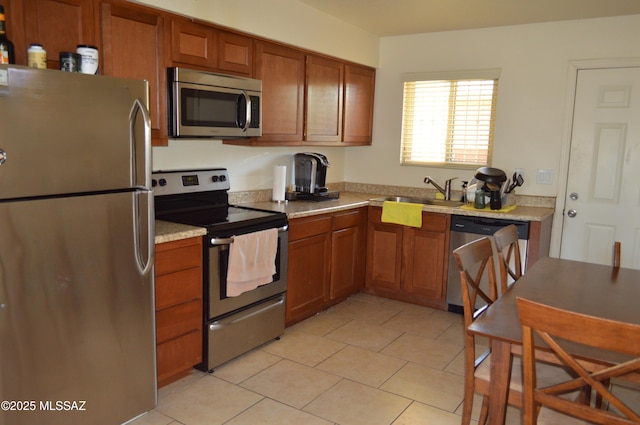 1809 E Miles St, Tucson, AZ 85719 - kitchen with appliances with stainless steel finishes, brown cabinets, light tile patterned floors, and light countertops