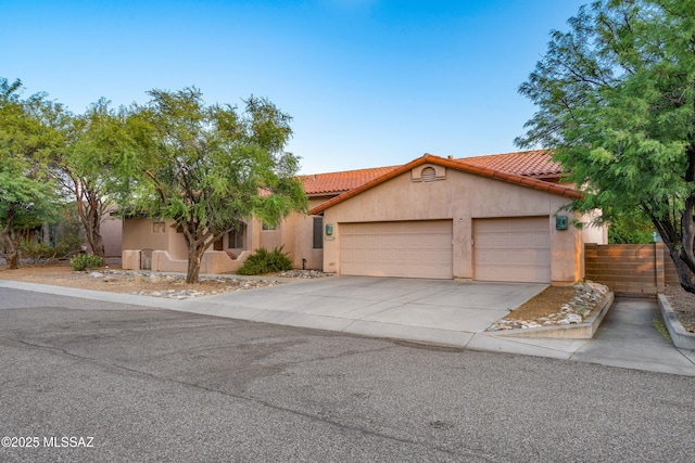 11120 E Mountain Gate Pl, Tucson, AZ 85749 - view of front of property featuring stucco siding, an attached garage, a tile roof, and concrete driveway