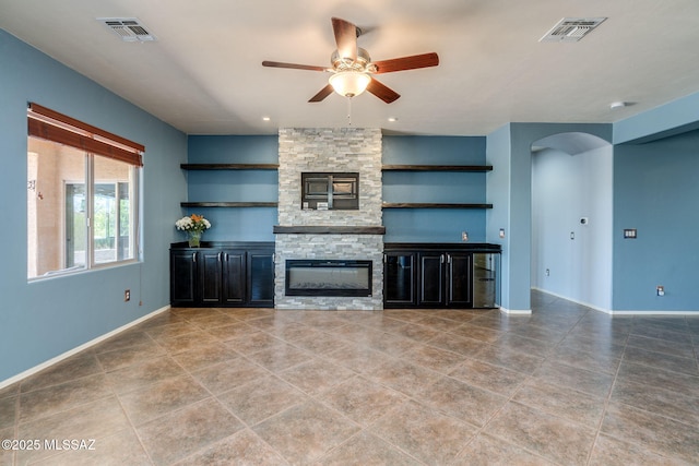 9407 E Greek Sage Way, Vail, AZ 85641 - unfurnished living room with ceiling fan, arched walkways, light tile patterned floors, and a stone fireplace