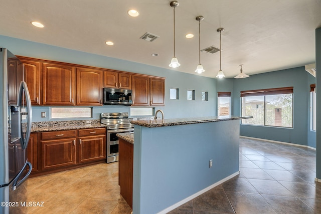 9407 E Greek Sage Way, Vail, AZ 85641 - kitchen with appliances with stainless steel finishes, stone counters, light tile patterned floors, decorative light fixtures, and an island with sink