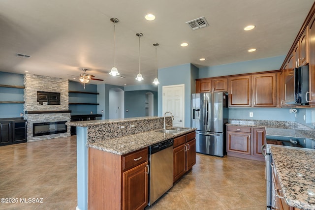 9407 E Greek Sage Way, Vail, AZ 85641 - kitchen with stainless steel appliances, arched walkways, ceiling fan, a fireplace, and light stone countertops
