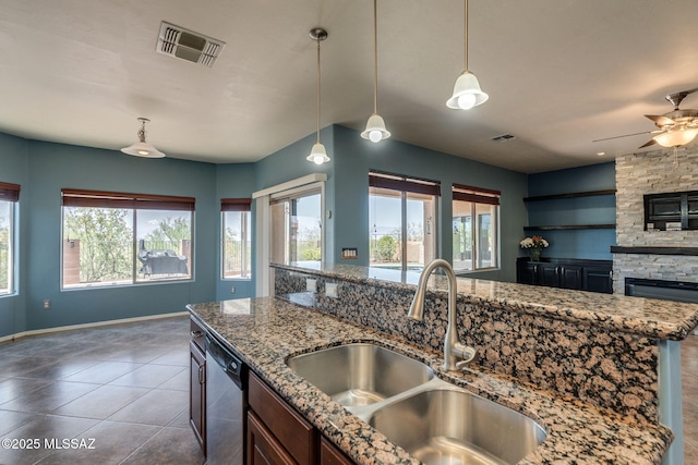 9407 E Greek Sage Way, Vail, AZ 85641 - kitchen with dishwasher, a stone fireplace, tile patterned flooring, a ceiling fan, and open floor plan