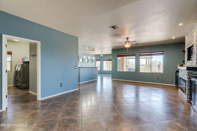9407 E Greek Sage Way, Vail, AZ 85641 - unfurnished living room featuring ceiling fan, a stone fireplace, washer / clothes dryer, and dark tile patterned floors