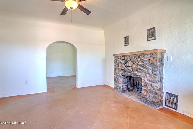 1125 W Huron St, Tucson, AZ 85745 - unfurnished living room with a fireplace, a ceiling fan, tile patterned flooring, and arched walkways