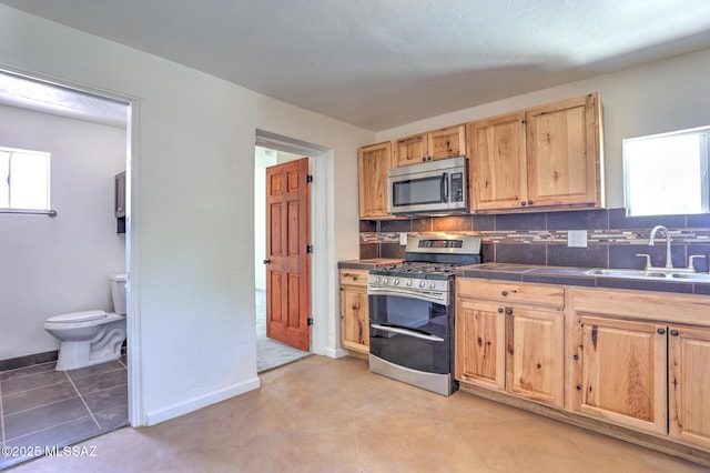 1125 W Huron St, Tucson, AZ 85745 - kitchen featuring stainless steel appliances, light brown cabinets, and tasteful backsplash