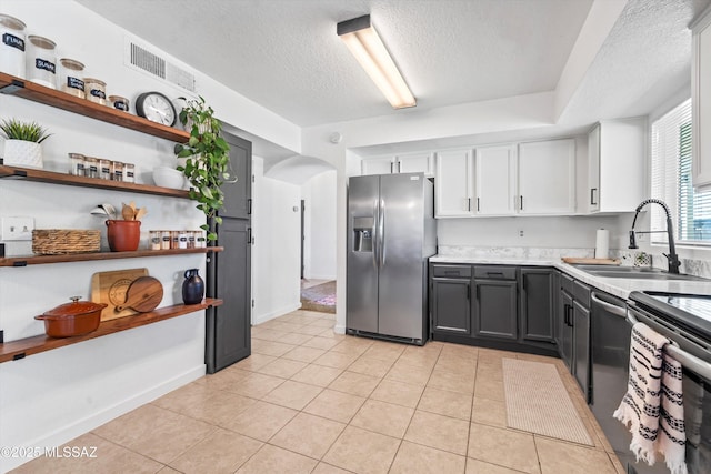 1441 N Calle De Durazo, Tucson, AZ 85715 - kitchen featuring appliances with stainless steel finishes, a textured ceiling, arched walkways, white cabinets, and light countertops