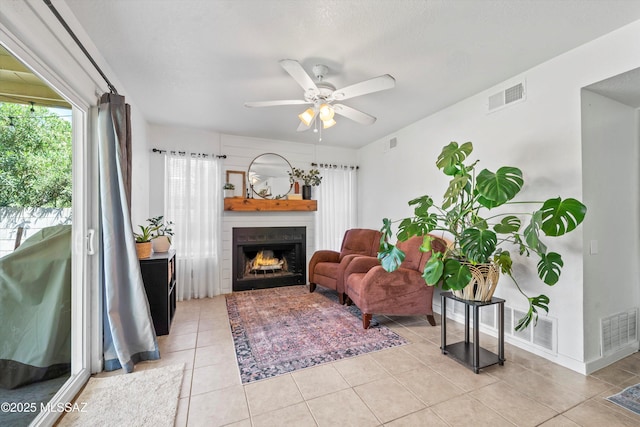 1441 N Calle De Durazo, Tucson, AZ 85715 - living room featuring a lit fireplace, a ceiling fan, and light tile patterned flooring