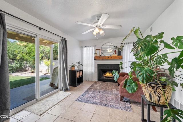 1441 N Calle De Durazo, Tucson, AZ 85715 - tiled living room featuring a warm lit fireplace and a ceiling fan