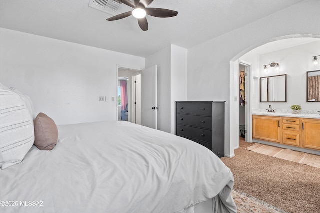 1441 N Calle De Durazo, Tucson, AZ 85715 - bedroom with arched walkways, light colored carpet, ensuite bathroom, and ceiling fan