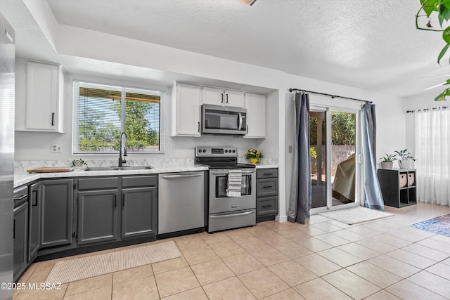 1441 N Calle De Durazo, Tucson, AZ 85715 - kitchen featuring appliances with stainless steel finishes, light countertops, white cabinetry, a textured ceiling, and light tile patterned floors
