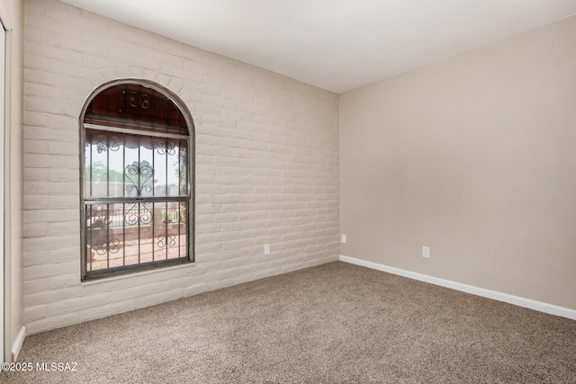 7208 E Toronto St, Tucson, AZ 85730 - carpeted empty room featuring brick wall and baseboards