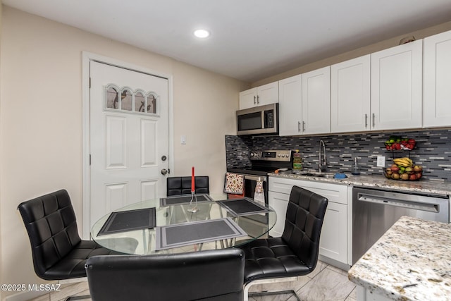 801 W Idaho St, Tucson, AZ 85706 - kitchen with appliances with stainless steel finishes, tasteful backsplash, white cabinetry, recessed lighting, and light stone countertops