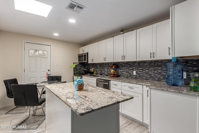 801 W Idaho St, Tucson, AZ 85706 - kitchen with stainless steel appliances, a kitchen island, recessed lighting, tasteful backsplash, and light stone countertops