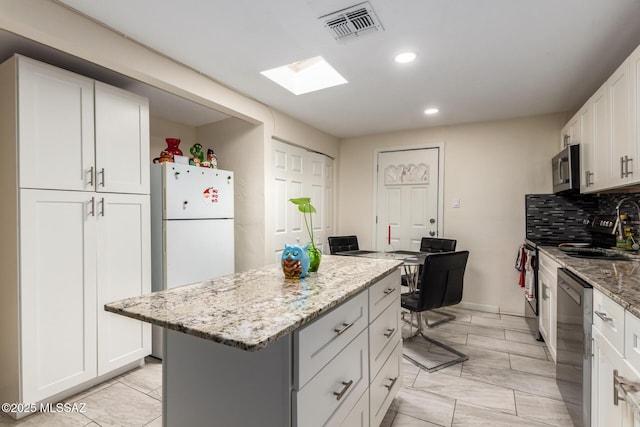 801 W Idaho St, Tucson, AZ 85706 - kitchen with appliances with stainless steel finishes, light stone countertops, a kitchen island, recessed lighting, and tasteful backsplash