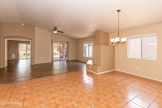 5566 W Dove Of Peace Dr, Marana, AZ 85658 - empty room featuring vaulted ceiling, a ceiling fan, a chandelier, light tile patterned floors, and arched walkways