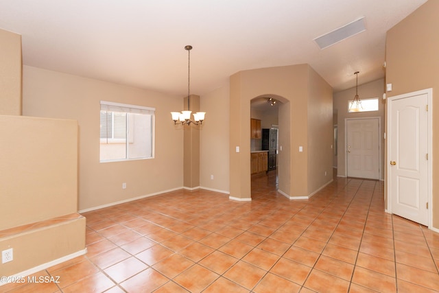 5566 W Dove Of Peace Dr, Marana, AZ 85658 - empty room with light tile patterned floors, a chandelier, arched walkways, and vaulted ceiling