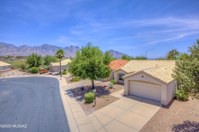 13491 N Tom Ryans Way, Oro Valley, AZ 85755 - view of front facade featuring a tile roof, a mountain view, stucco siding, an attached garage, and driveway