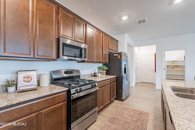 10490 W Beaman Ln, Marana, AZ 85653 - kitchen with stainless steel appliances, light wood-type flooring, light stone countertops, and recessed lighting