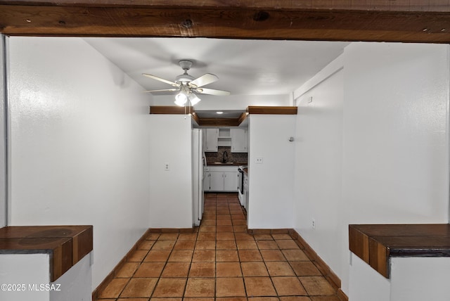 4812 E 3rd St, Tucson, AZ 85711 - kitchen with decorative backsplash, dark countertops, white cabinetry, freestanding refrigerator, and a ceiling fan