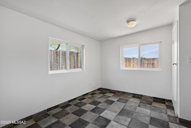 4812 E 3rd St, Tucson, AZ 85711 - empty room featuring dark stone finish floors and baseboards