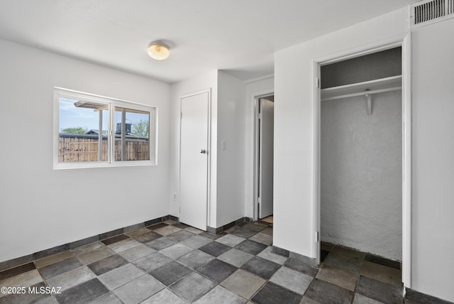 4812 E 3rd St, Tucson, AZ 85711 - unfurnished bedroom featuring stone finish floors and a closet