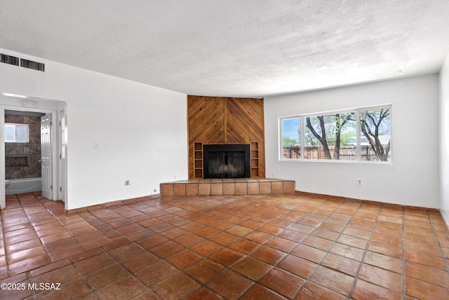 4812 E 3rd St, Tucson, AZ 85711 - unfurnished living room with a fireplace, a textured ceiling, and tile patterned floors