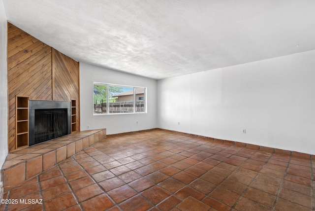 4812 E 3rd St, Tucson, AZ 85711 - unfurnished living room featuring a fireplace and wood walls