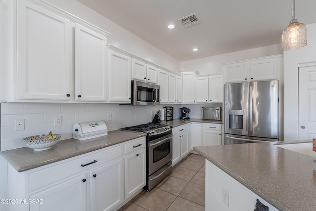 10567 E Desert Drifter Pl, Tucson, AZ 85747 - kitchen featuring appliances with stainless steel finishes, white cabinets, tasteful backsplash, light tile patterned flooring, and recessed lighting
