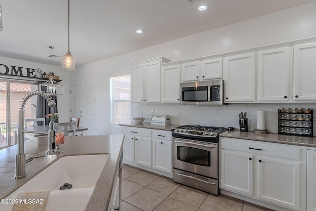 10567 E Desert Drifter Pl, Tucson, AZ 85747 - kitchen with appliances with stainless steel finishes, plenty of natural light, decorative backsplash, white cabinetry, and recessed lighting