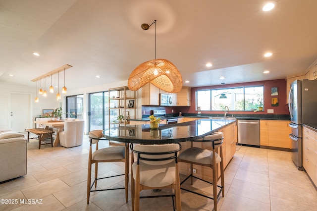 1115 W Santo Domingo Cir, Tucson, AZ 85704 - kitchen featuring appliances with stainless steel finishes, light brown cabinetry, recessed lighting, light tile patterned floors, and a kitchen bar