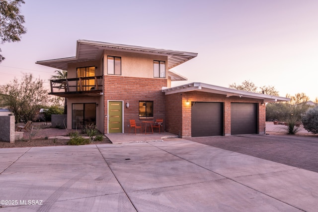 1115 W Santo Domingo Cir, Tucson, AZ 85704 - contemporary home with a balcony, driveway, brick siding, and an attached garage