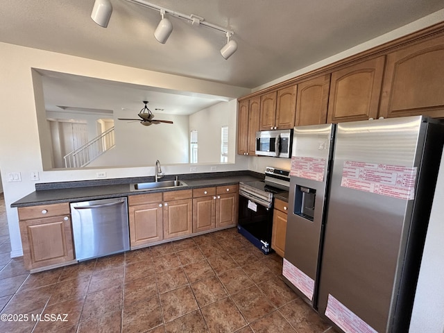 3365 N River Rapids Dr, Tucson, AZ 85712 - kitchen featuring stainless steel appliances, dark countertops, a ceiling fan, rail lighting, and brown cabinetry