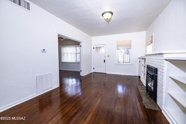 1809 E 8th St, Tucson, AZ 85719 - unfurnished living room featuring a brick fireplace and hardwood / wood-style floors