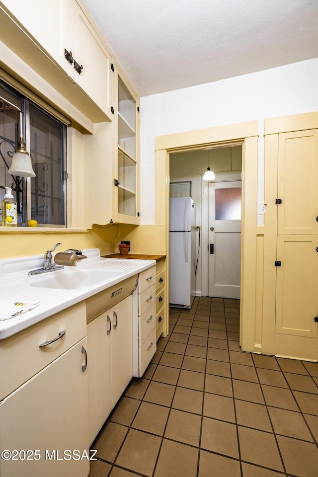 1809 E 8th St, Tucson, AZ 85719 - kitchen featuring light tile patterned floors, freestanding refrigerator, light countertops, and white cabinetry