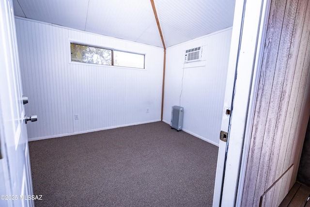 1809 E 8th St, Tucson, AZ 85719 - unfurnished room featuring radiator heating unit, dark carpet, a wall unit AC, and wood walls