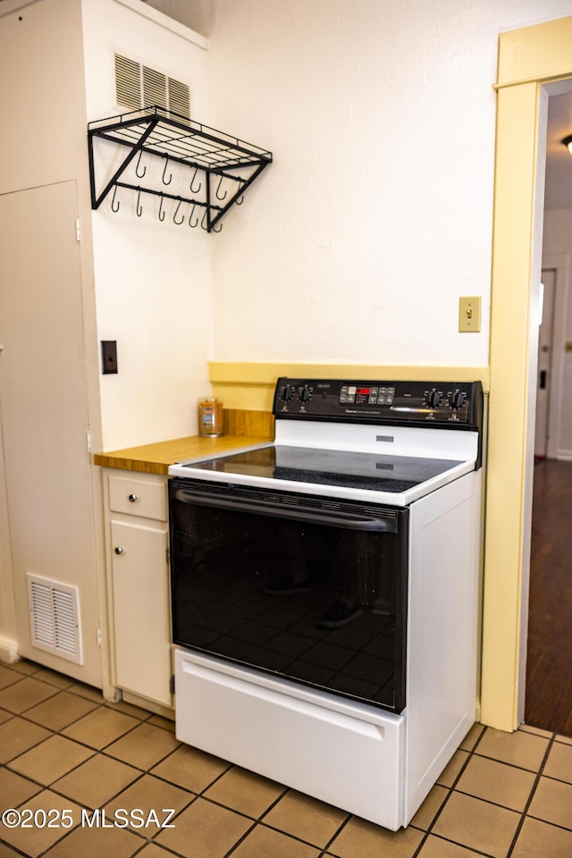 1809 E 8th St, Tucson, AZ 85719 - kitchen with electric stove, light tile patterned flooring, white cabinets, and light countertops