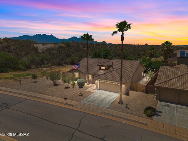1026 E Madera Estates Ln, Sahuarita, AZ 85629 - view of front of house featuring a garage, driveway, a tile roof, a mountain view, and stucco siding