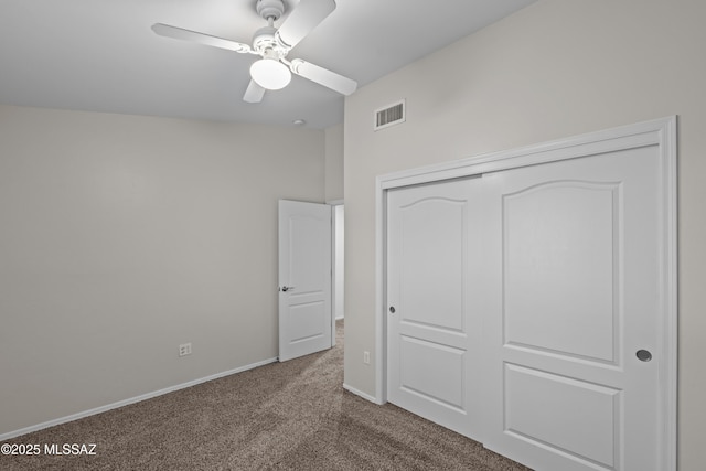 1026 E Madera Estates Ln, Sahuarita, AZ 85629 - unfurnished bedroom with dark colored carpet, a closet, and a ceiling fan