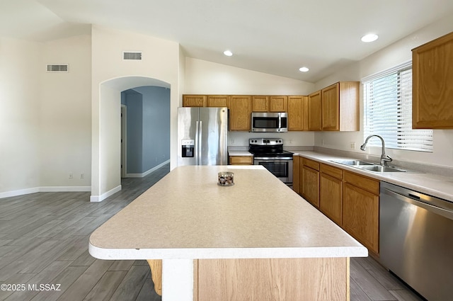 2898 W Simplicity Dr, Tucson, AZ 85741 - kitchen featuring stainless steel appliances, lofted ceiling, arched walkways, light countertops, and a kitchen island